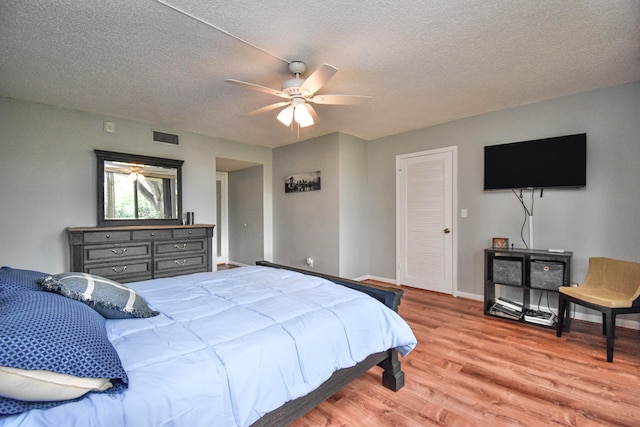 bedroom featuring ceiling fan, a textured ceiling, and light hardwood / wood-style flooring