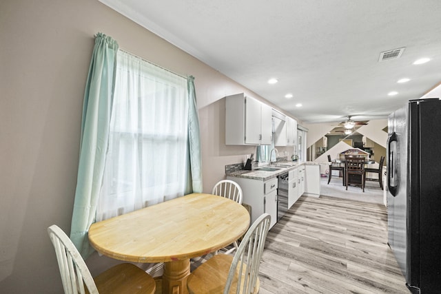 dining space with ceiling fan, sink, and light hardwood / wood-style floors