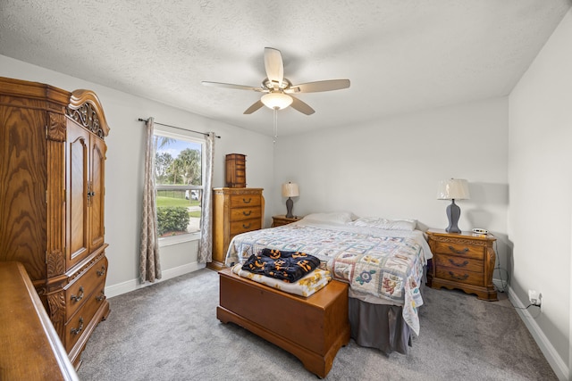 carpeted bedroom featuring a textured ceiling and ceiling fan