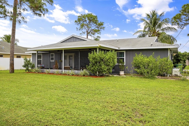 back of property featuring a sunroom and a yard