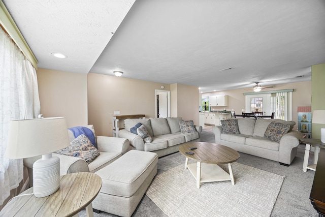 carpeted living room featuring ceiling fan