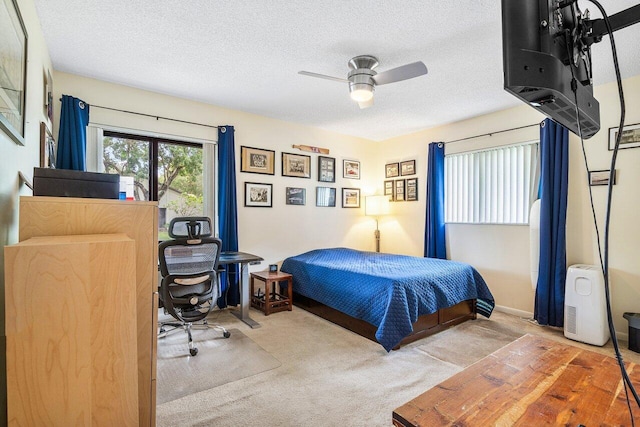 bedroom with ceiling fan, a textured ceiling, and carpet floors