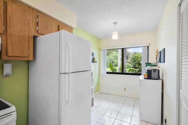 kitchen with hanging light fixtures, a textured ceiling, light tile patterned floors, and white refrigerator