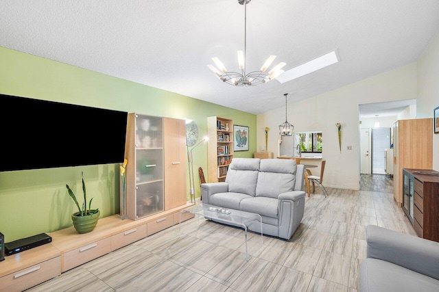 living room featuring a textured ceiling, a chandelier, and vaulted ceiling with skylight