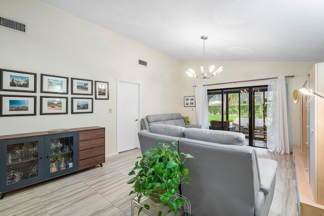 living room featuring a chandelier, lofted ceiling, and a textured ceiling