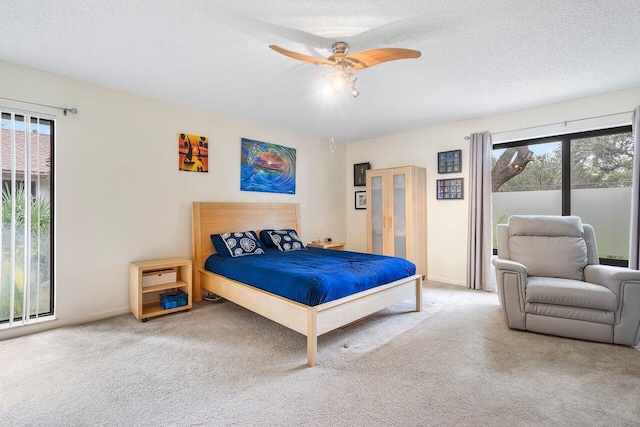 carpeted bedroom with a textured ceiling and ceiling fan