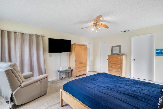 carpeted bedroom featuring a textured ceiling and ceiling fan