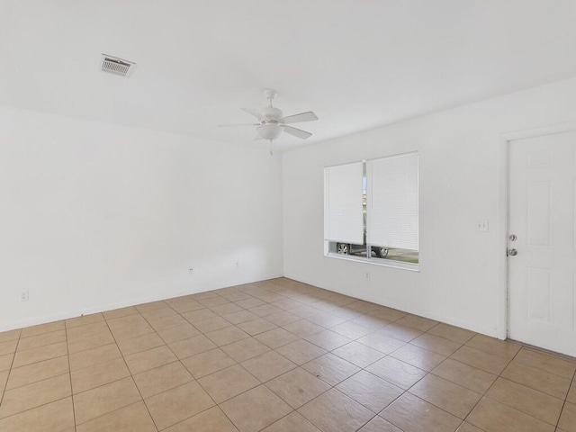 tiled spare room with a ceiling fan