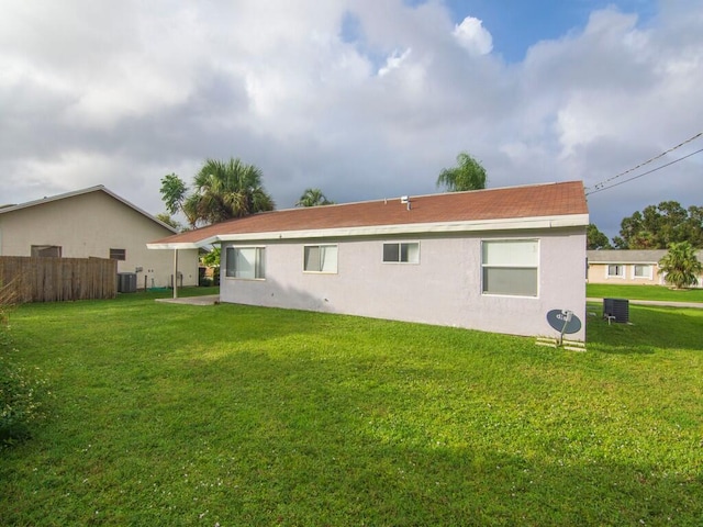 rear view of house featuring central AC unit and stucco siding