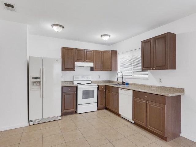 kitchen with white appliances, under cabinet range hood, a sink, baseboards, and light tile patterned flooring