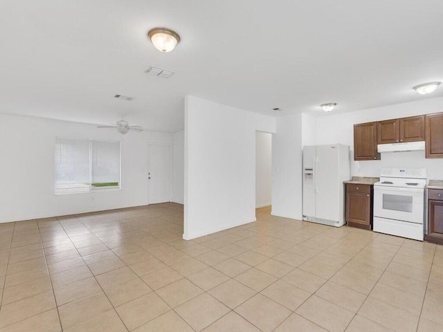 kitchen featuring white appliances, under cabinet range hood, open floor plan, and light countertops