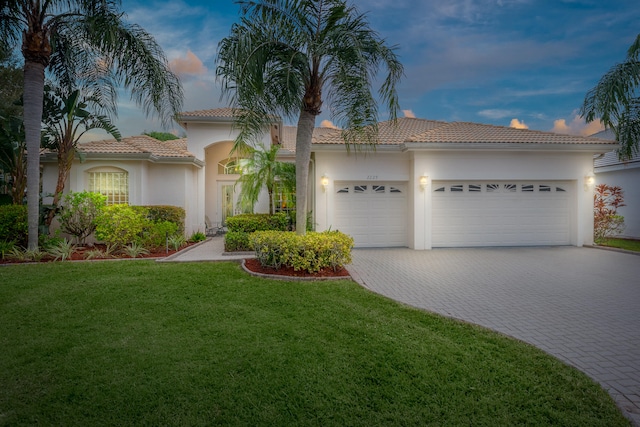 mediterranean / spanish house featuring a garage and a yard