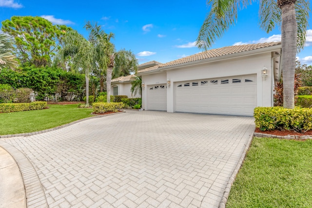 mediterranean / spanish-style home with a garage and a front yard