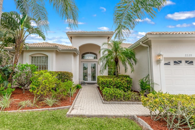 property entrance featuring a garage and french doors