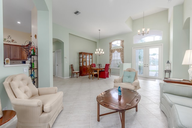 living room with a high ceiling, light tile patterned floors, french doors, and a notable chandelier