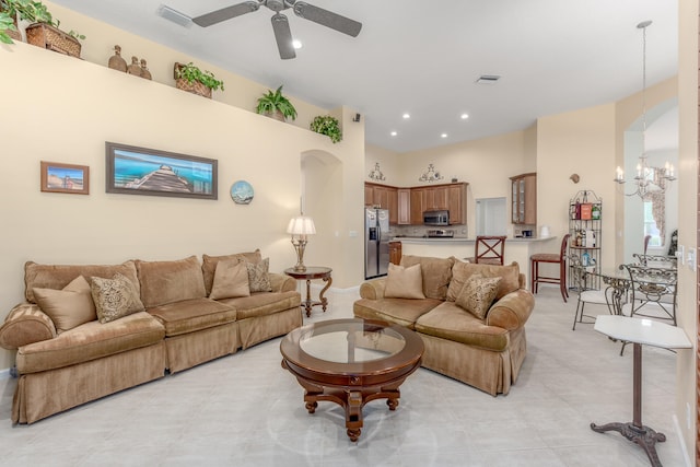 living room with ceiling fan with notable chandelier