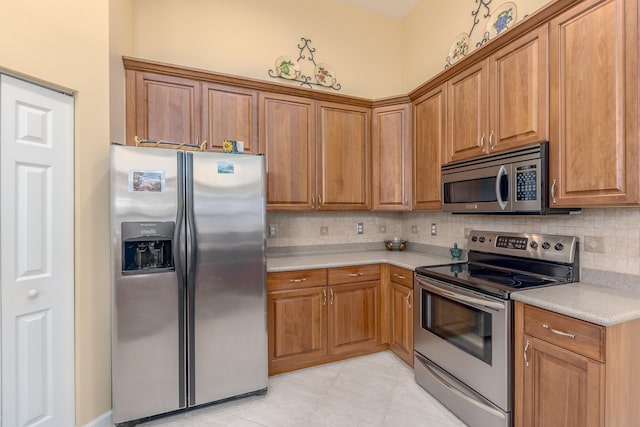 kitchen featuring appliances with stainless steel finishes, light tile patterned floors, and tasteful backsplash