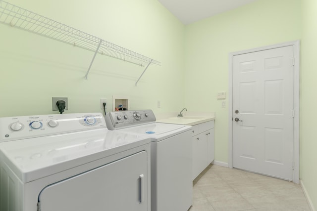 laundry room with cabinets, washing machine and dryer, sink, and light tile patterned flooring