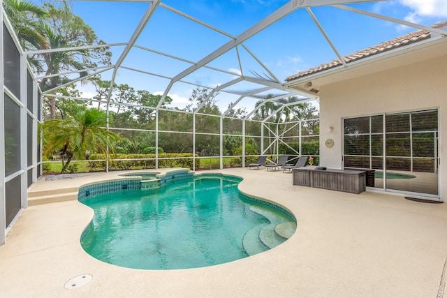 view of pool with a lanai, an in ground hot tub, and a patio area