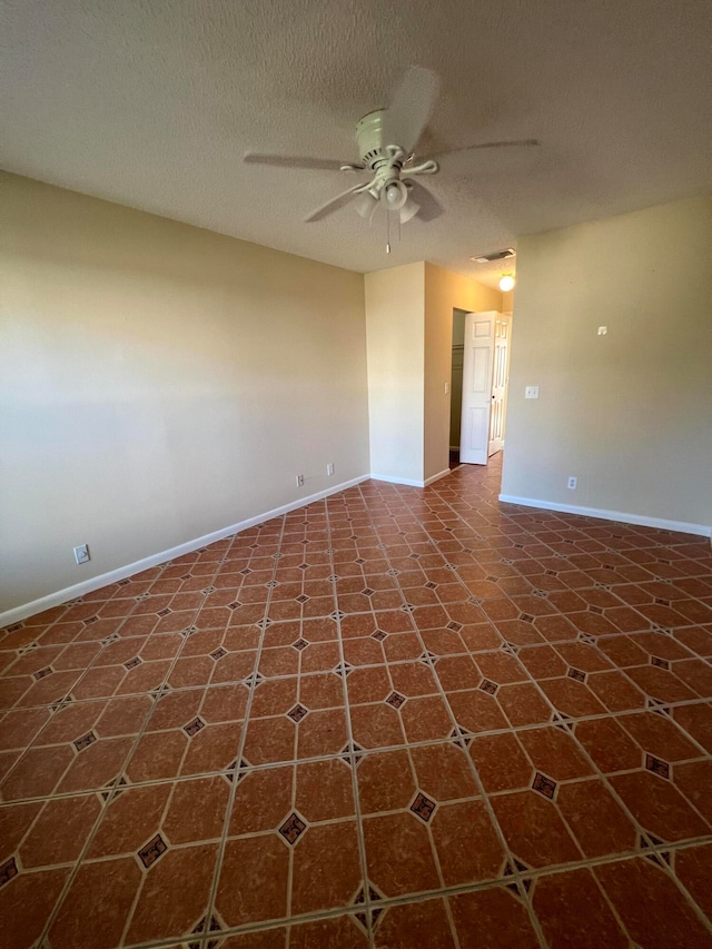 empty room featuring a textured ceiling and ceiling fan