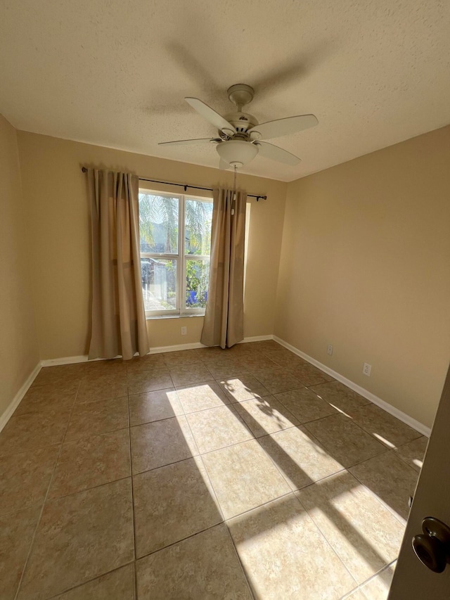 spare room featuring a textured ceiling, tile patterned flooring, and ceiling fan