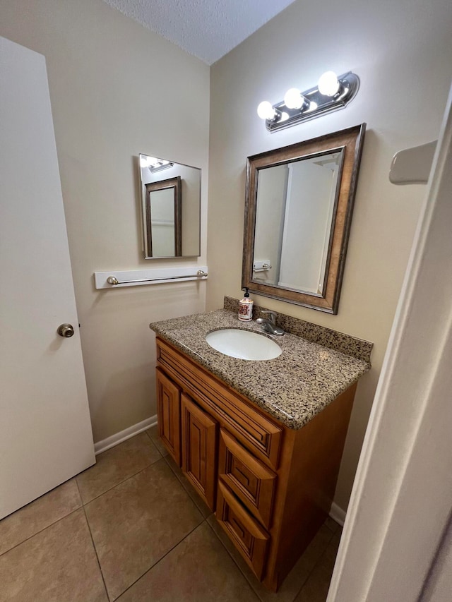 bathroom featuring tile patterned flooring, vanity, and a textured ceiling