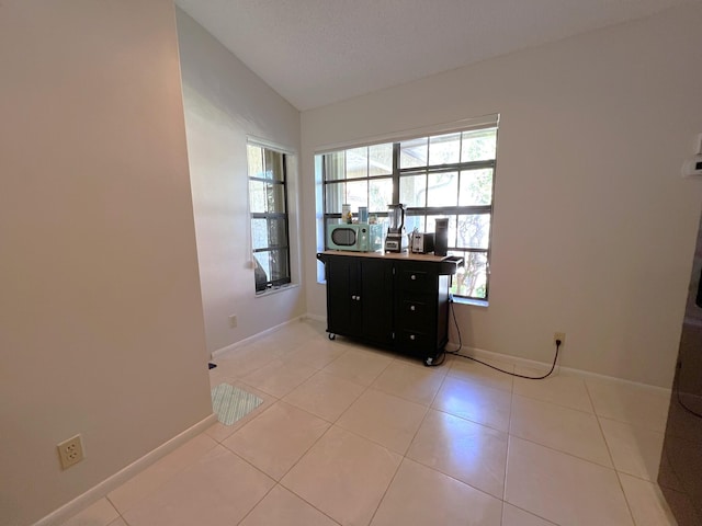 interior space with tile patterned floors, a textured ceiling, and lofted ceiling