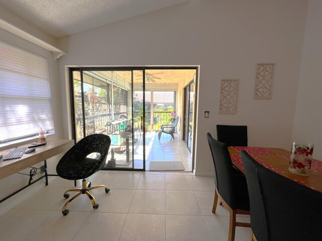 office space featuring a textured ceiling, lofted ceiling, and light tile patterned floors