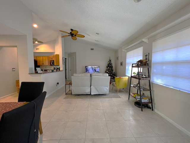 tiled living room with a textured ceiling, ceiling fan, and vaulted ceiling