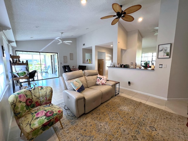 living room with ceiling fan, a wealth of natural light, lofted ceiling, and light tile patterned floors