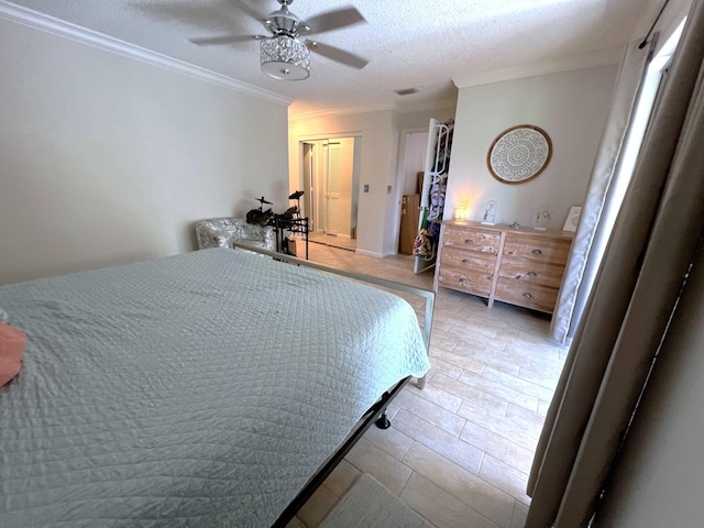 bedroom featuring ornamental molding, a textured ceiling, ceiling fan, and light hardwood / wood-style flooring