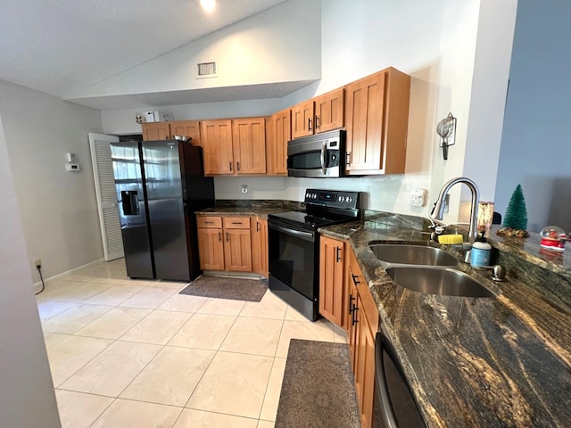 kitchen featuring black appliances, sink, light tile patterned floors, high vaulted ceiling, and dark stone countertops