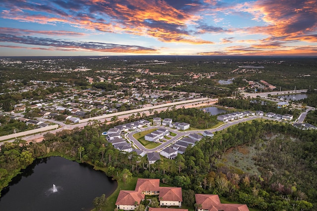 aerial view at dusk featuring a water view