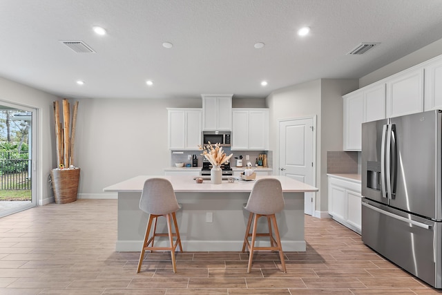 200 SW Pomeroy St, Stuart, FL 34997 - kitchen with appliances with stainless steel finishes, tasteful backsplash, recessed lighting, light wood-style floors, and light countertops