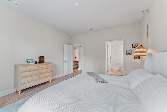 bedroom featuring hardwood / wood-style floors and ensuite bath