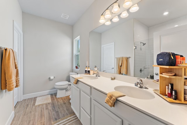 200 SW Pomeroy St, Stuart, FL 34997 - bathroom with tiled shower, double vanity, toilet, wood tiled floors, and baseboards