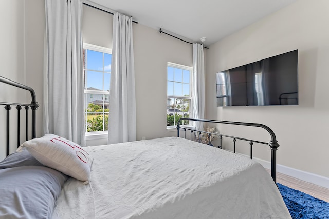 200 SW Pomeroy St, Stuart, FL 34997 - bedroom featuring multiple windows, baseboards, and wood finished floors