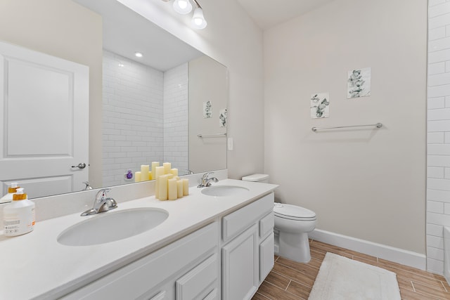 bathroom featuring vanity, toilet, and tiled shower