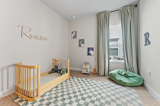 bedroom featuring light hardwood / wood-style floors and a crib