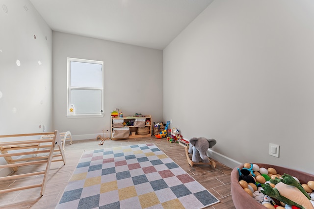 rec room featuring hardwood / wood-style floors and lofted ceiling