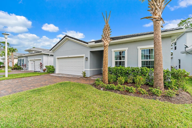 200 SW Pomeroy St, Stuart, FL 34997 - ranch-style house with a front lawn, decorative driveway, an attached garage, stucco siding, and a tile roof