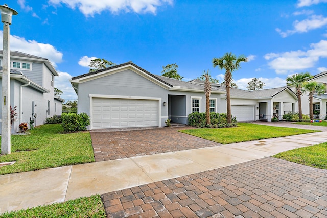 200 SW Pomeroy St, Stuart, FL 34997 - ranch-style home with a garage, decorative driveway, a front lawn, and stucco siding