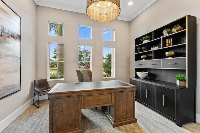 office area featuring light carpet, a healthy amount of sunlight, and crown molding