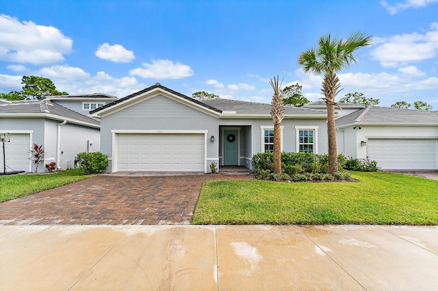 200 SW Pomeroy St, Stuart, FL 34997 - view of front of house featuring decorative driveway, a front yard, stucco siding, and a garage
