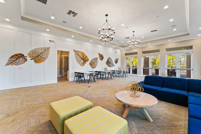 living room featuring light parquet flooring, a chandelier, french doors, and a raised ceiling