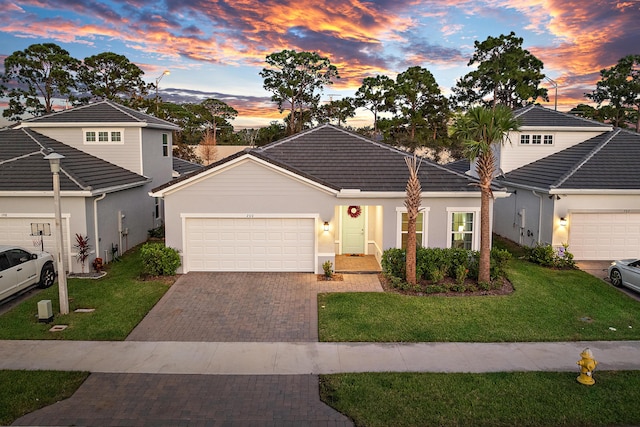 200 SW Pomeroy St, Stuart, FL 34997 - view of front of home with a garage, a tile roof, driveway, a front yard, and stucco siding
