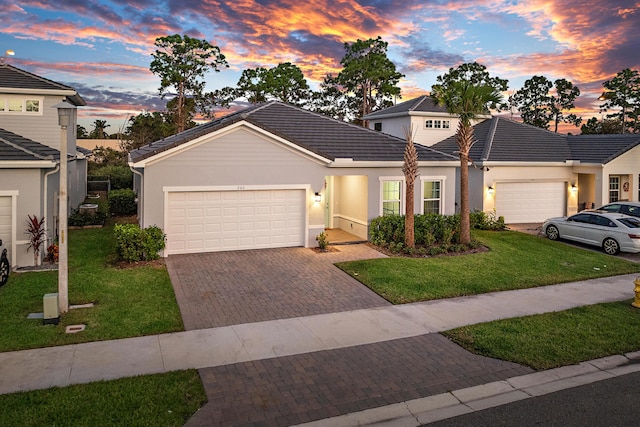 200 SW Pomeroy St, Stuart, FL 34997 - view of front of home featuring an attached garage, decorative driveway, a tiled roof, and a yard