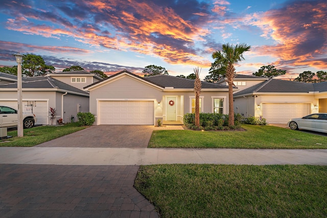 200 SW Pomeroy St, Stuart, FL 34997 - view of front of house with a garage, decorative driveway, stucco siding, a yard, and a tiled roof