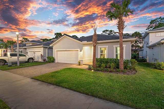 view of front of home with a garage and a yard