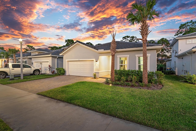 200 SW Pomeroy St, Stuart, FL 34997 - view of front of property with decorative driveway, a garage, stucco siding, a front yard, and a tile roof
